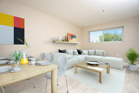 a living room and dining room with white furniture and a table and chairs